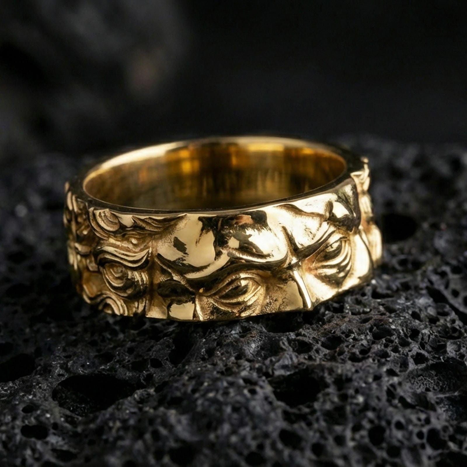 Gold plated Michelangelo Moses spinner band ring on volcanic rock, detailed portrait relief on rotating band with vintage scroll accents, luxury jewelry product photography.