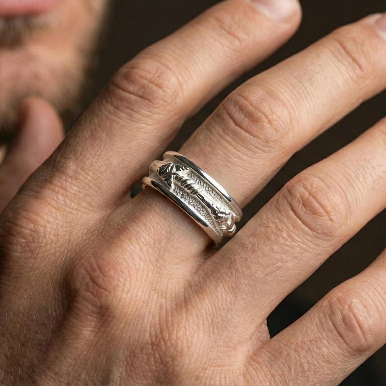 Polished silver arrow fidget spinner ring on finger, crisp arrowhead and wrapped shaft detail, refined everyday wear close-up.