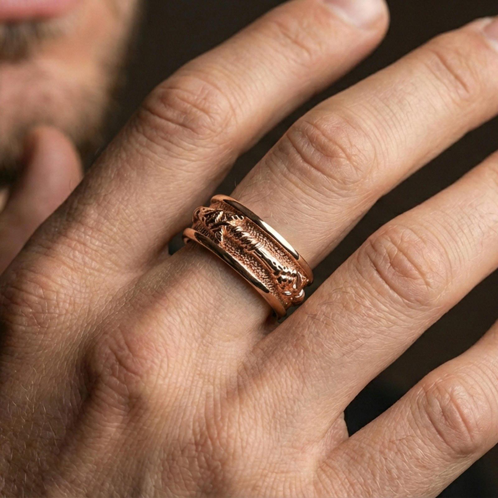 Rose gold plated arrow spinner ring worn on finger, sculpted arrowhead and wrapped shaft relief detail, elegant lifestyle wear shot.