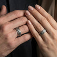 Load image into Gallery viewer, Oxidized sterling silver tree branch band worn on finger, branch and leaf engraving detail, natural lifestyle hand shot with shallow depth of field.
