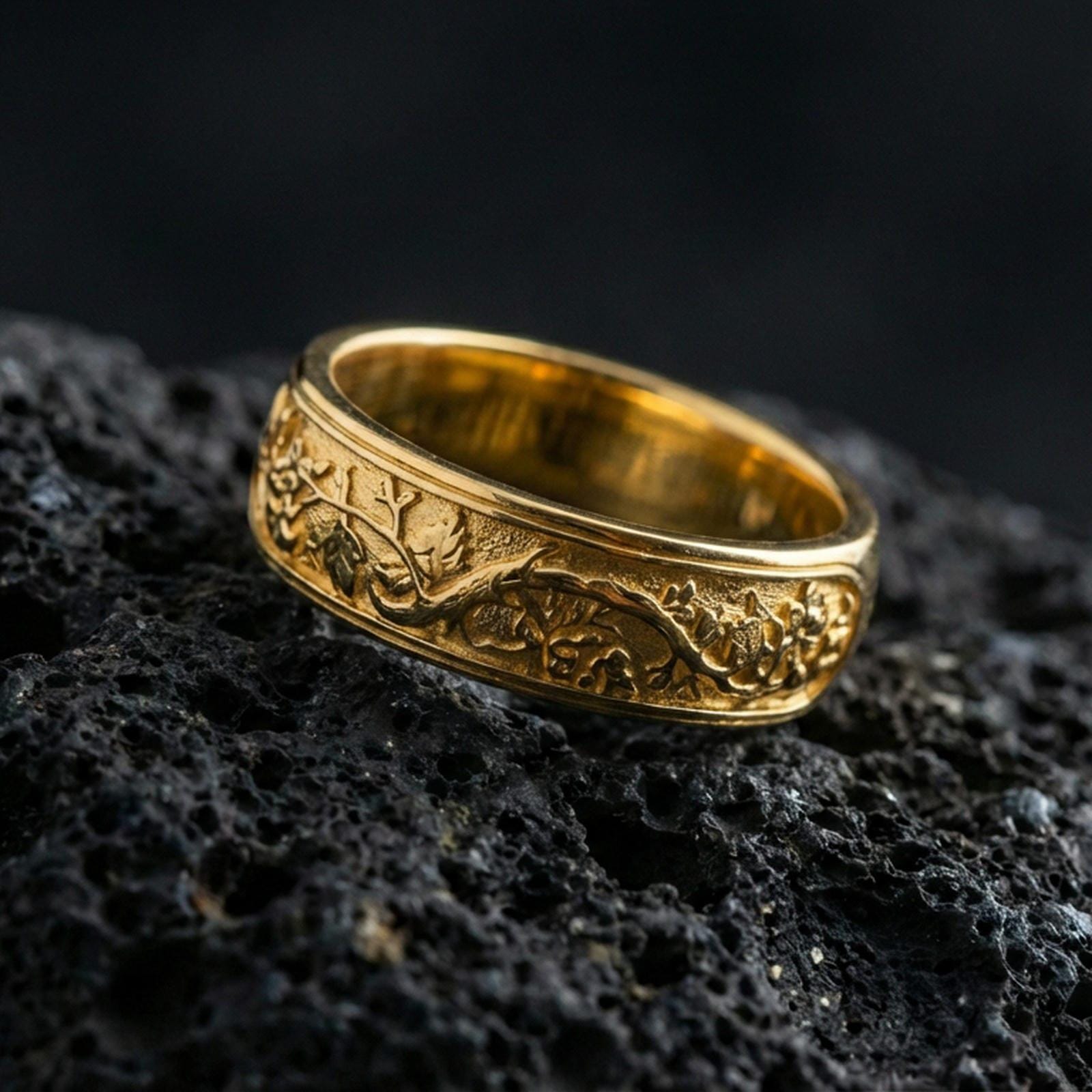 Gold plated tree roots band ring on volcanic rock, detailed branch and leaf engraving with organic texture, luxury jewelry product photography.