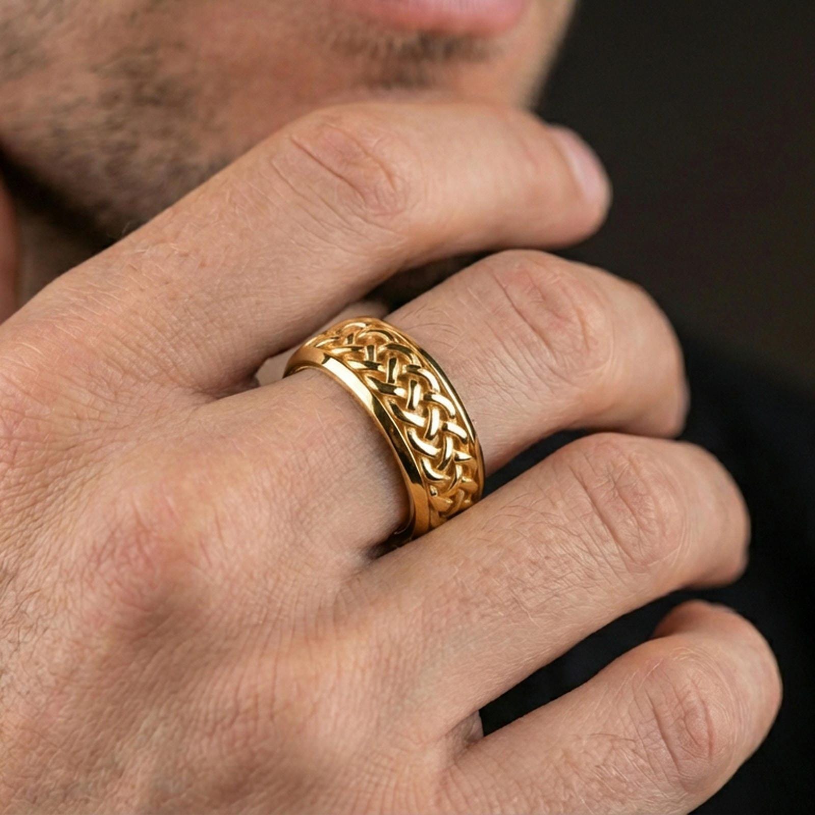 Gold plated Celtic knot woven band ring worn on finger, raised braid pattern with rich highlights, premium lifestyle jewelry photo.