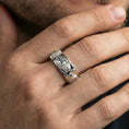 Load image into Gallery viewer, Polished silver wolf and deer wildlife band worn on finger, bright reflective relief with crisp definition, natural everyday wear shot.
