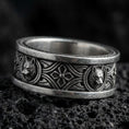 Load image into Gallery viewer, Oxidized sterling silver wolf ring on black volcanic rock, Celtic knot band with raised wolf medallions, crisp macro product photo with deep contrast.
