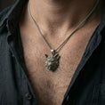 Load image into Gallery viewer, Oxidized wolf head pendant worn on the neck in a lifestyle jewelry shot, styled against the chest for a bold and nature-inspired statement look
