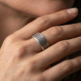 Load image into Gallery viewer, Oxidized sterling silver square-grid ring worn on finger, deep contrast in the recessed grid for a bold structured look, lifestyle hand close-up.
