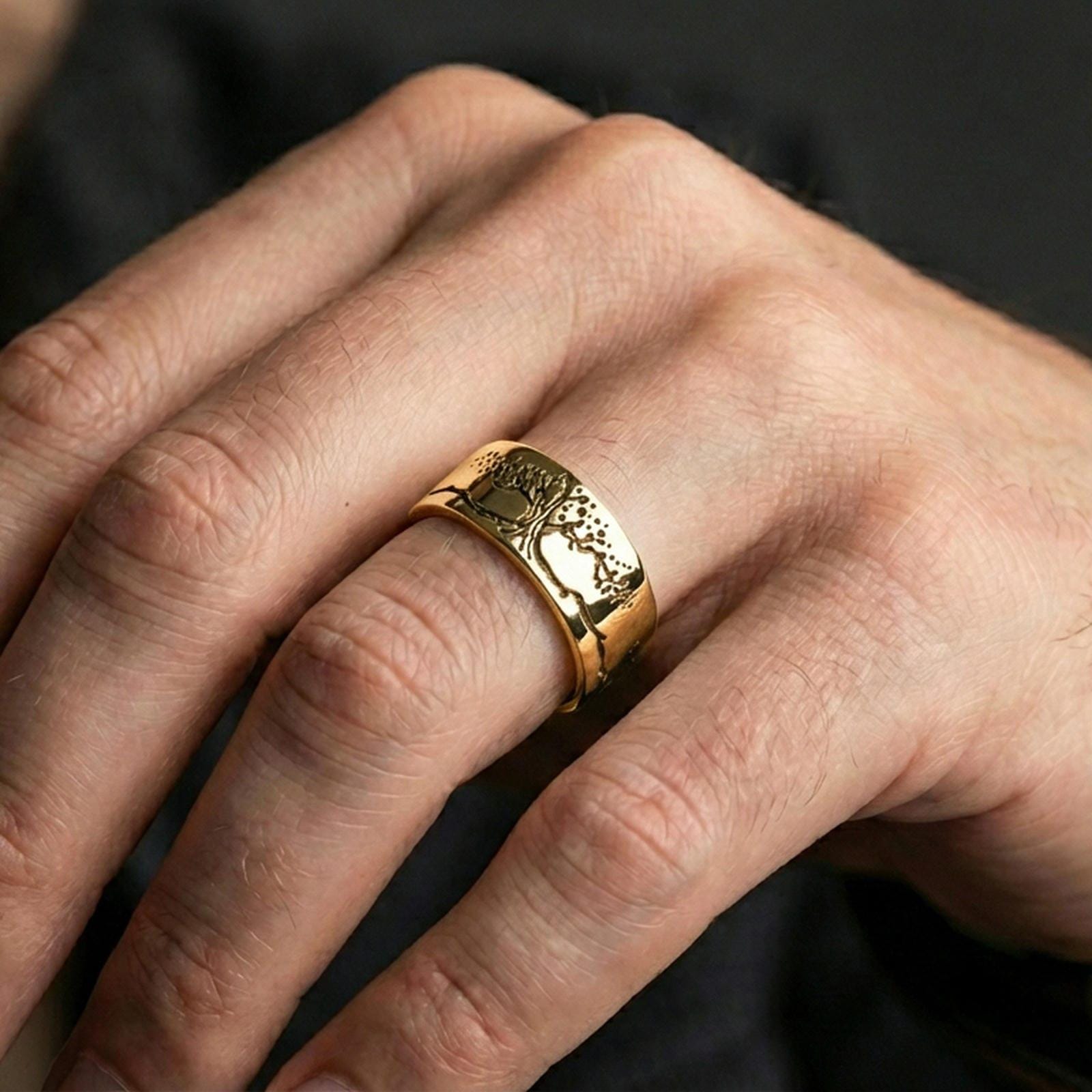Gold plated Tree of Life ring worn on finger, rich warm tone emphasizing the tree-and-horizon engraving, lifestyle jewelry shot.
