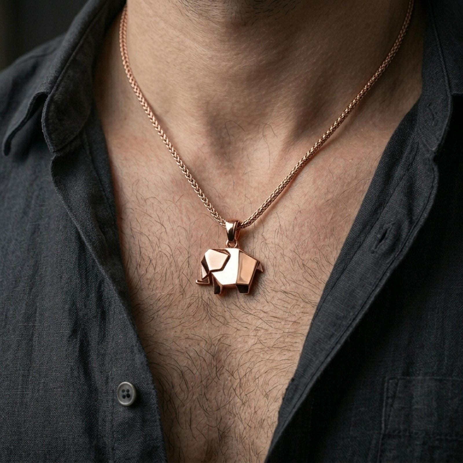 Rose gold plated geometric elephant necklace with sleek folded elephant form worn on the neck in a refined lifestyle shot with a warm and elegant presentation