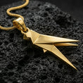 Load image into Gallery viewer, Gold plated origami bird pendant with sharp geometric folds, modern parrot silhouette, and clean sculptural design showcased on black volcanic rock in a refined macro jewelry image

