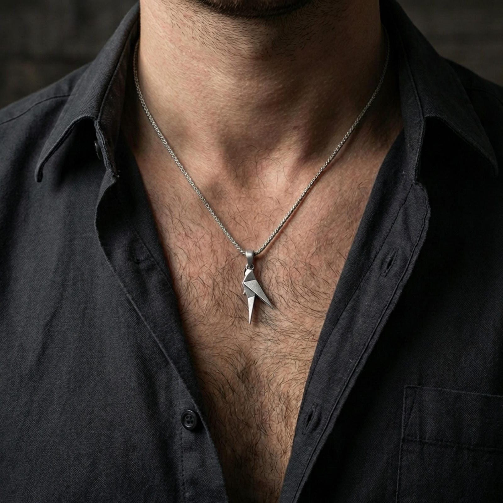 Oxidized origami parrot pendant worn on the neck in a lifestyle jewelry shot, styled against the chest for a bold and modern statement look