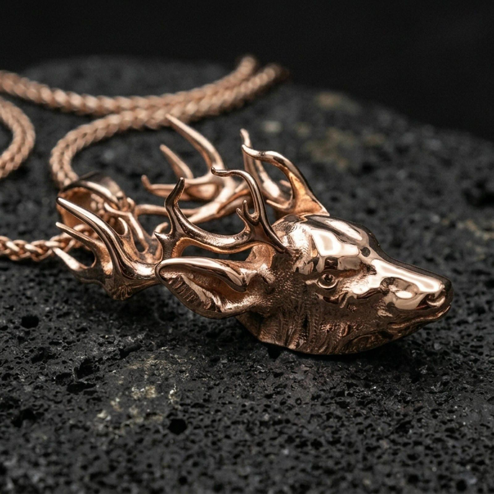 Rose gold plated deer pendant with detailed stag profile, sculpted antlers, and elegant forest animal form resting on volcanic rock in an elegant close-up product presentation