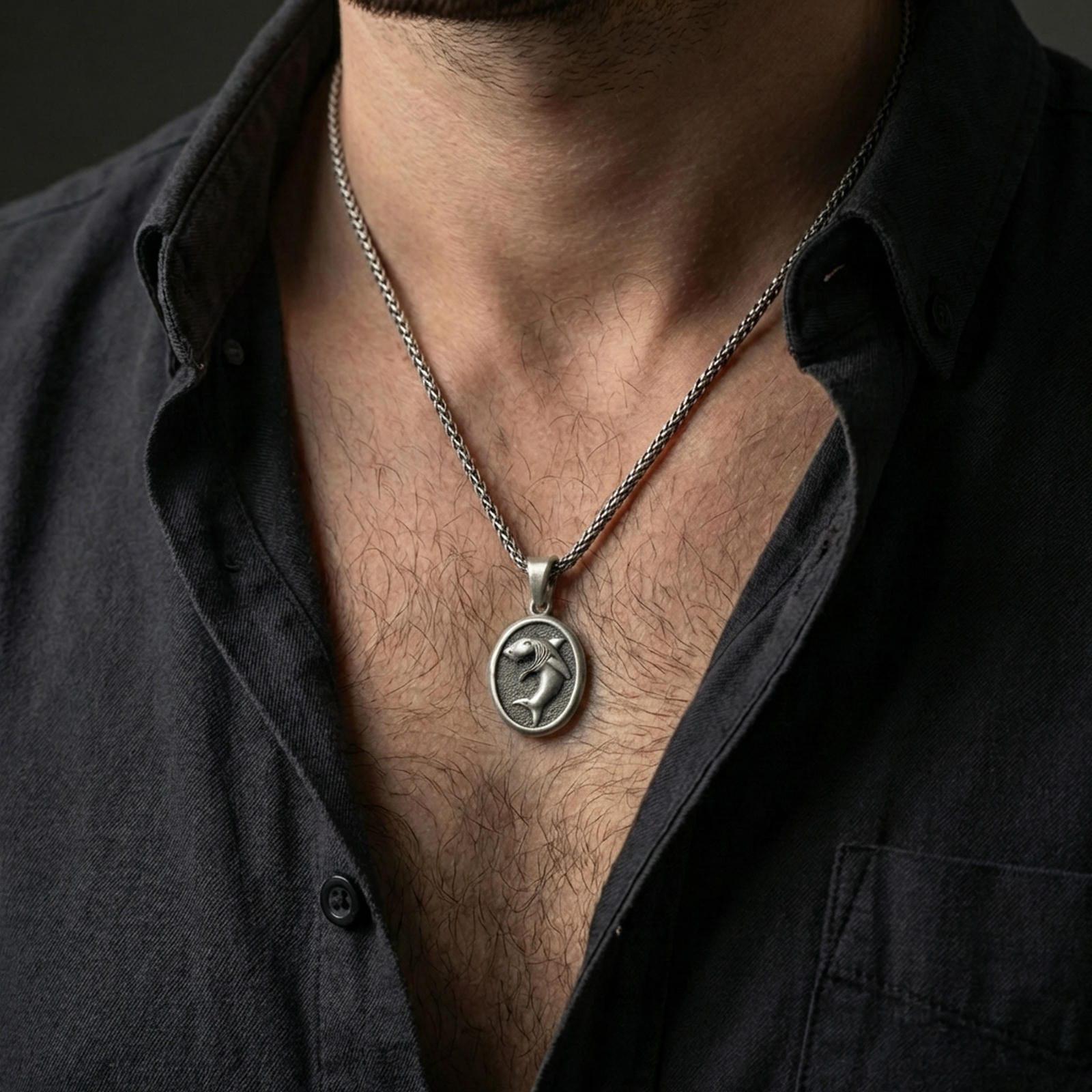 Oxidized shark pendant with fierce shark relief worn on the neck in a lifestyle jewelry shot, styled against the chest for a bold and ocean-inspired statement look