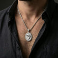 Load image into Gallery viewer, Polished silver shark necklace with open-mouth shark design worn on the neck in a close lifestyle frame, highlighting the oval medallion shape and detailed marine relief
