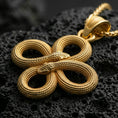 Load image into Gallery viewer, Gold plated snake knot pendant with interwoven serpent bodies, realistic scale relief, and elegant endless loop silhouette showcased on black volcanic rock in a refined macro jewelry image
