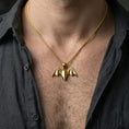 Load image into Gallery viewer, Gold plated origami bat pendant with angular wings and modern gothic styling worn on the neck in a premium lifestyle composition with strong alternative jewelry styling
