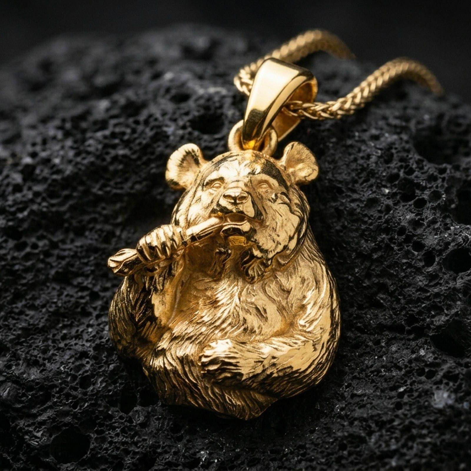 Gold plated panda pendant with detailed animal expression, textured fur surface, and charming bamboo motif showcased on black volcanic rock in a refined macro jewelry image