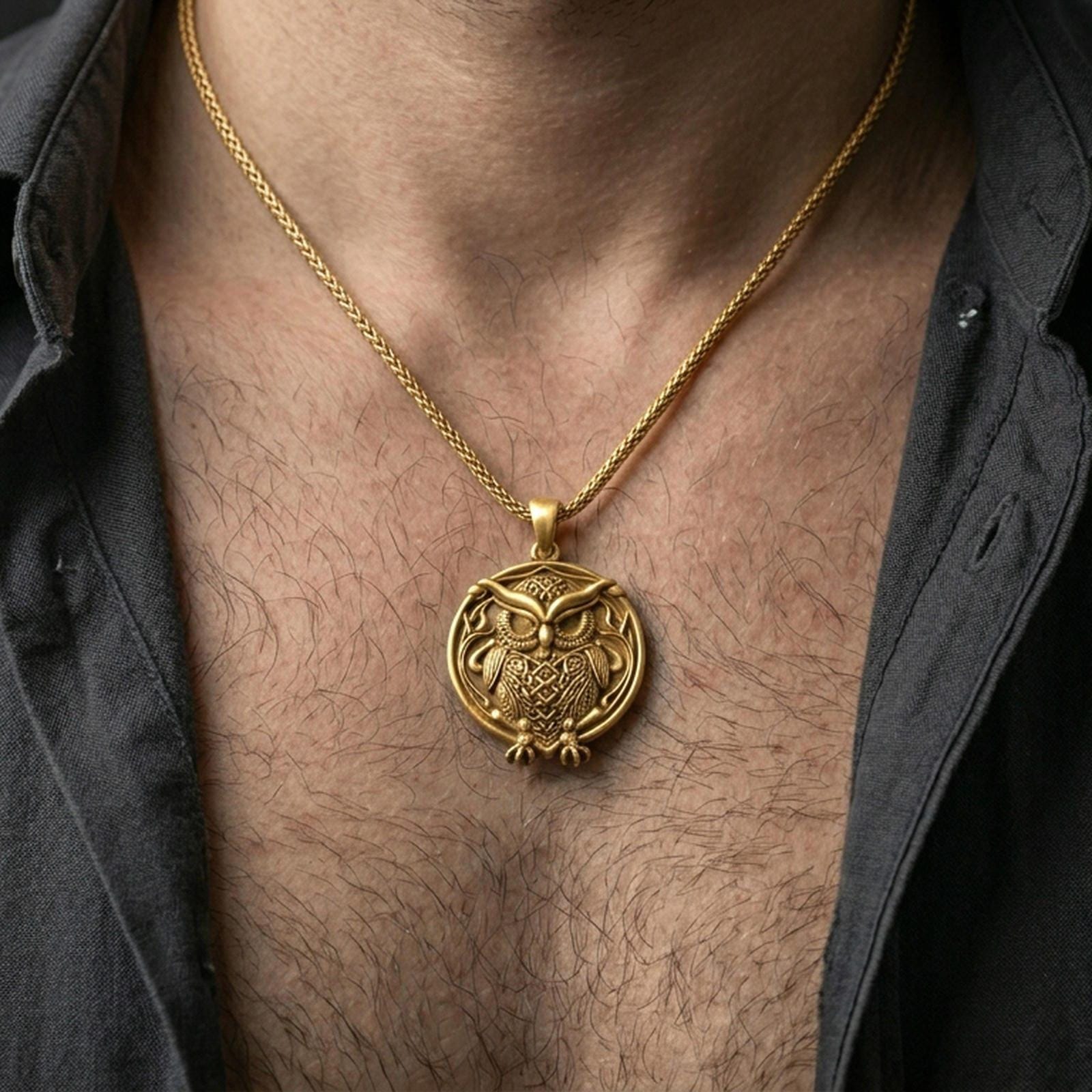 Gold plated owl pendant with intricate feather texture and round symbolic silhouette worn on the neck in a premium lifestyle composition with elegant bird-inspired jewelry styling
