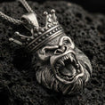 Load image into Gallery viewer, Oxidized gorilla king pendant with roaring ape face, detailed crown, and bold animal head silhouette displayed on dark volcanic rock in a close-up luxury jewelry composition

