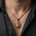 Load image into Gallery viewer, Rose gold plated owl necklace with sculpted feather detail, oval framed owl motif, and elegant nocturnal form worn on the neck in a refined lifestyle shot with a warm and sophisticated presentation
