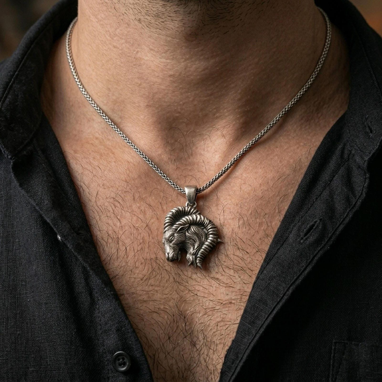 Oxidized Aries ram pendant with sculpted horn detail worn on the neck in a lifestyle jewelry shot, styled against the chest for a bold and zodiac-inspired statement look