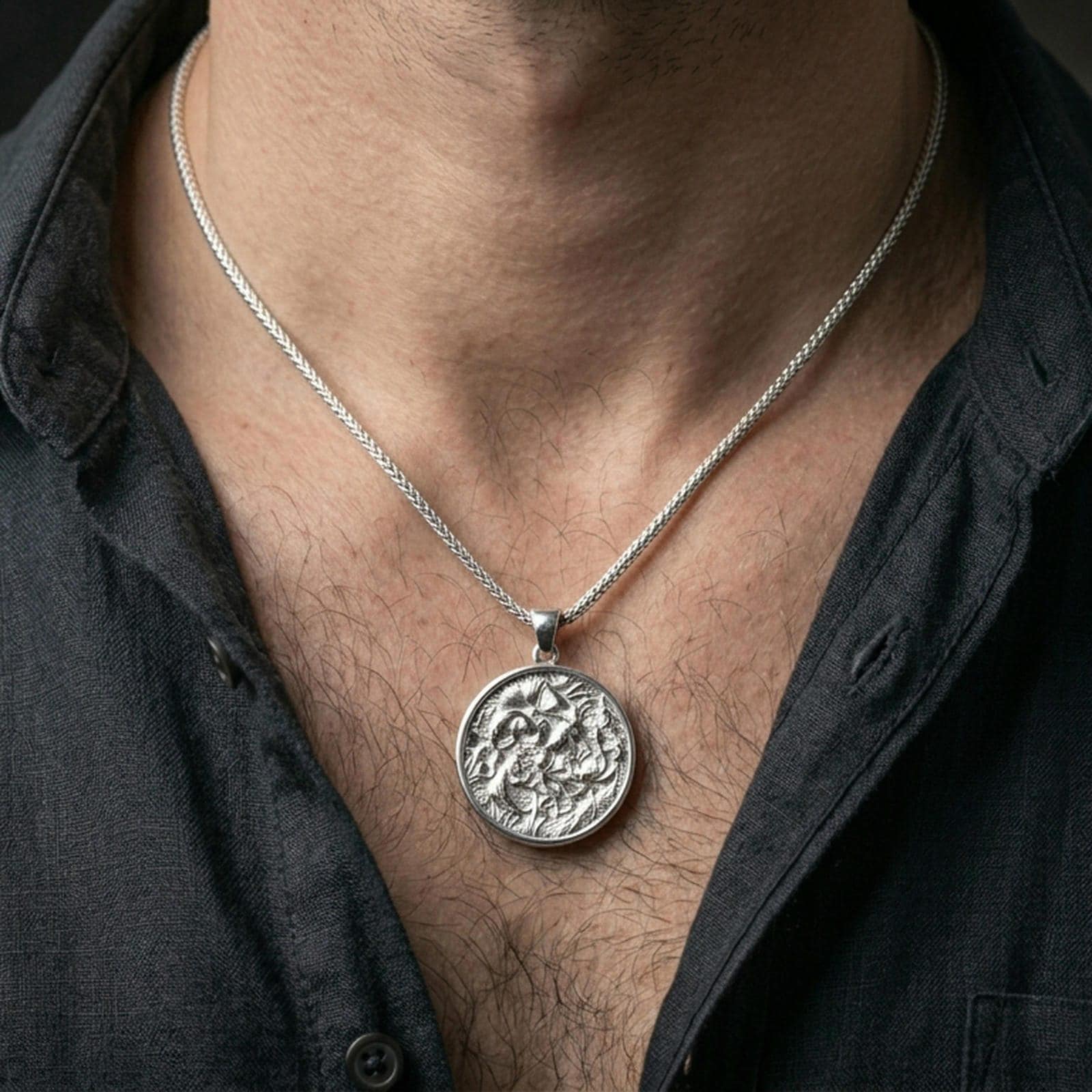 Polished silver koi fish necklace with round medallion shape and detailed lotus garden relief worn on the neck in a close lifestyle frame, highlighting the flowing aquatic composition and refined craftsmanship