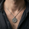 Load image into Gallery viewer, Oxidized koi fish pendant with lotus pond scene worn on the neck in a lifestyle jewelry shot, styled against the chest for a symbolic and nature-inspired statement look
