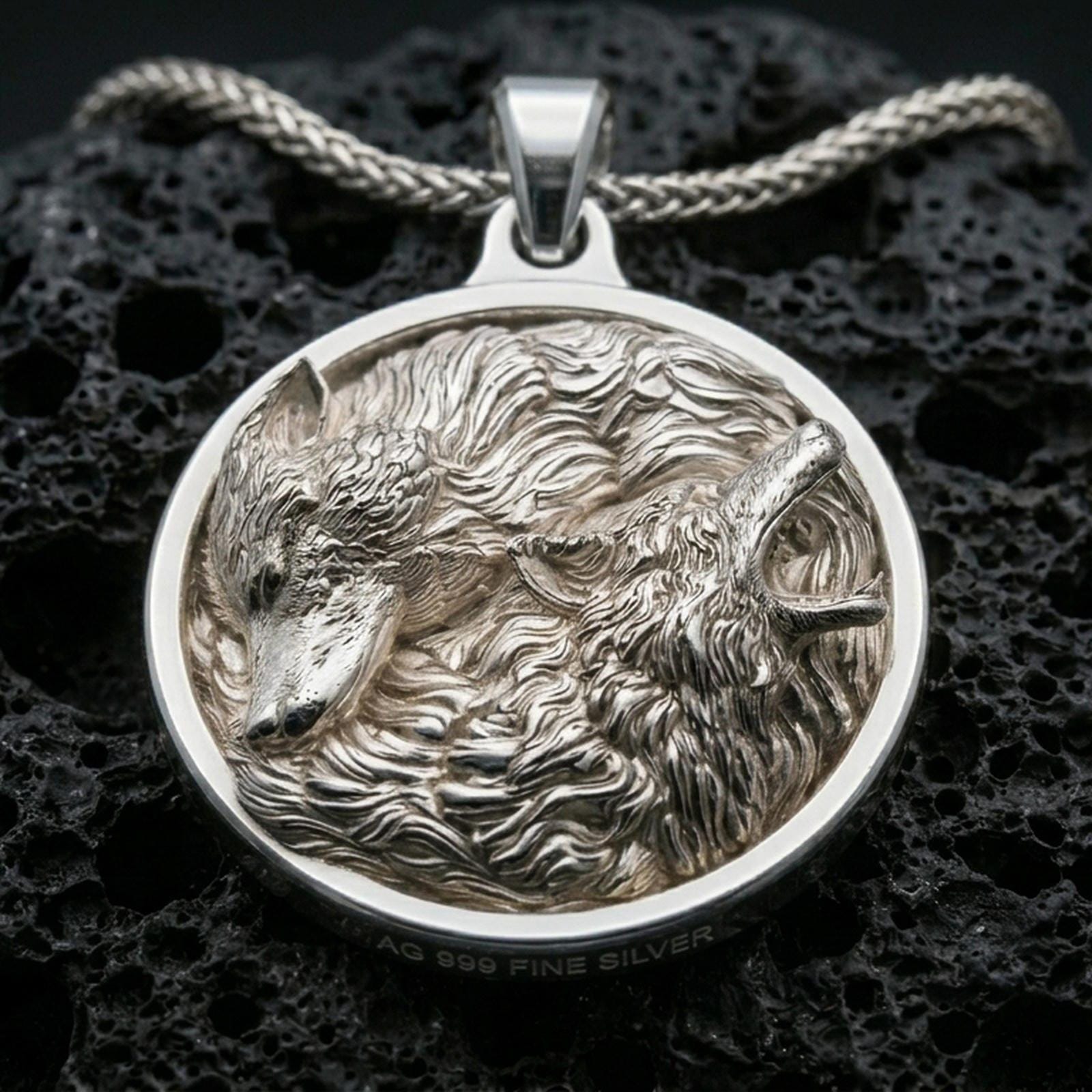 Polished silver wolf necklace with detailed twin wolf design, sculpted fur texture, and circular wilderness-inspired frame placed on textured volcanic rock in a premium studio product shot