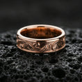 Load image into Gallery viewer, Rose gold plated floral pattern band ring on volcanic rock, soft warm tone enhancing the delicate engraved scrollwork and clean silhouette.
