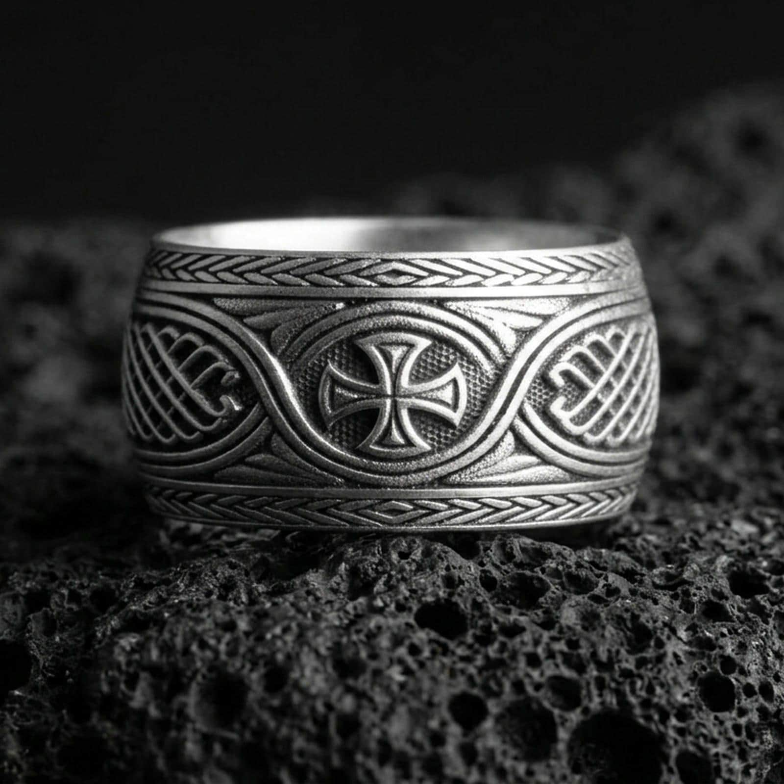 Oxidized sterling silver Celtic knot ring with iron cross centerpiece on black volcanic stone, darkened recessed details for a bold medieval look.