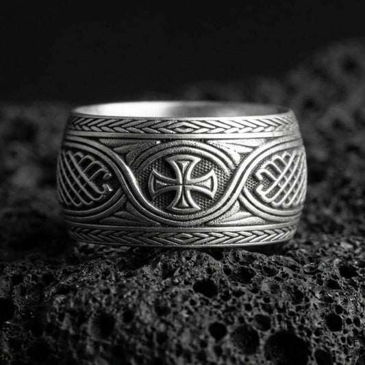 Oxidized sterling silver Celtic knot ring with iron cross centerpiece on black volcanic stone, darkened recessed details for a bold medieval look.