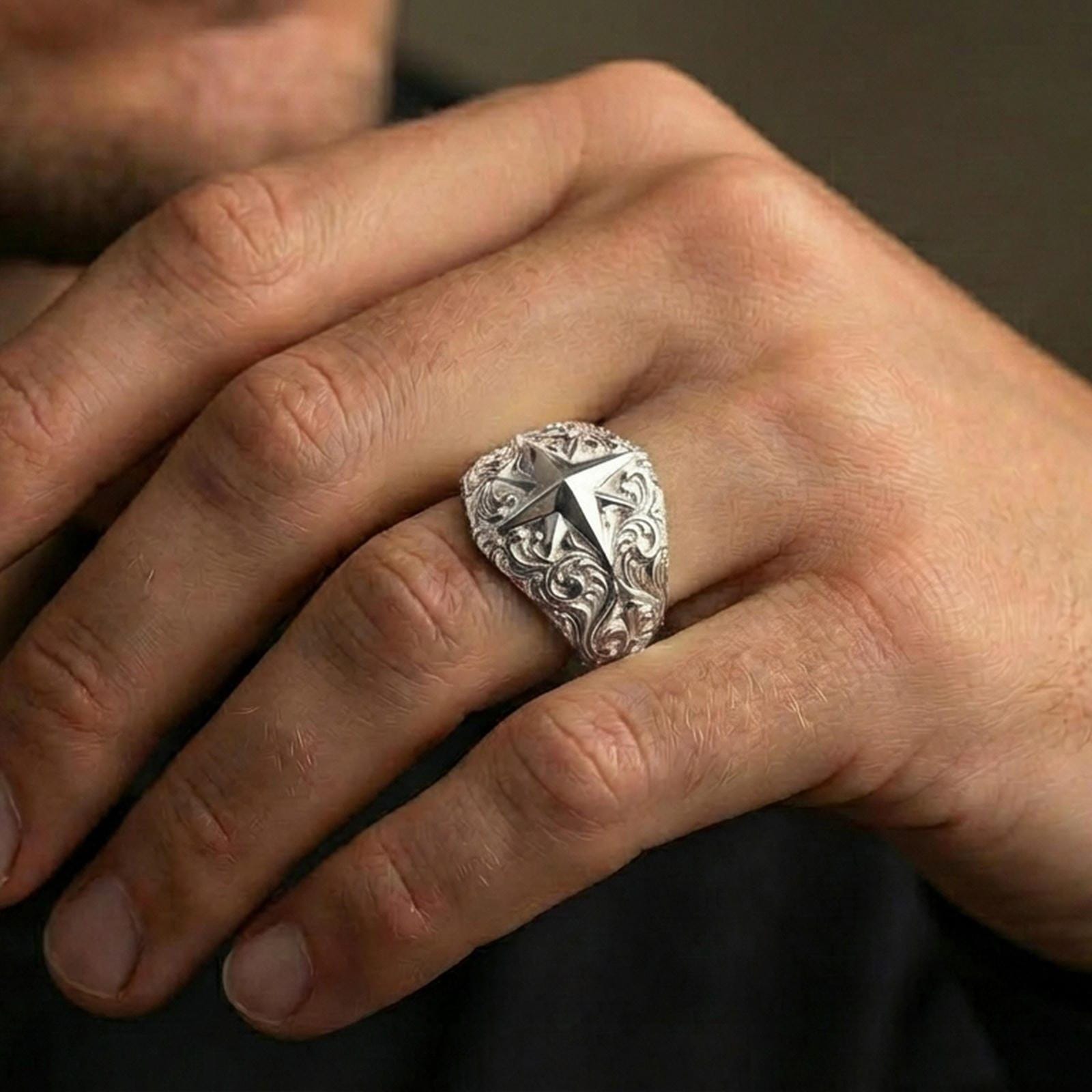 Polished silver North Star signet ring worn on finger, clean comfort fit with high-contrast star geometry and detailed hand-engraved swirls.