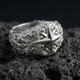 Load image into Gallery viewer, Polished silver North Star statement ring on volcanic rock, crisp eight-point star and engraved swirl relief captured in sharp macro detail.

