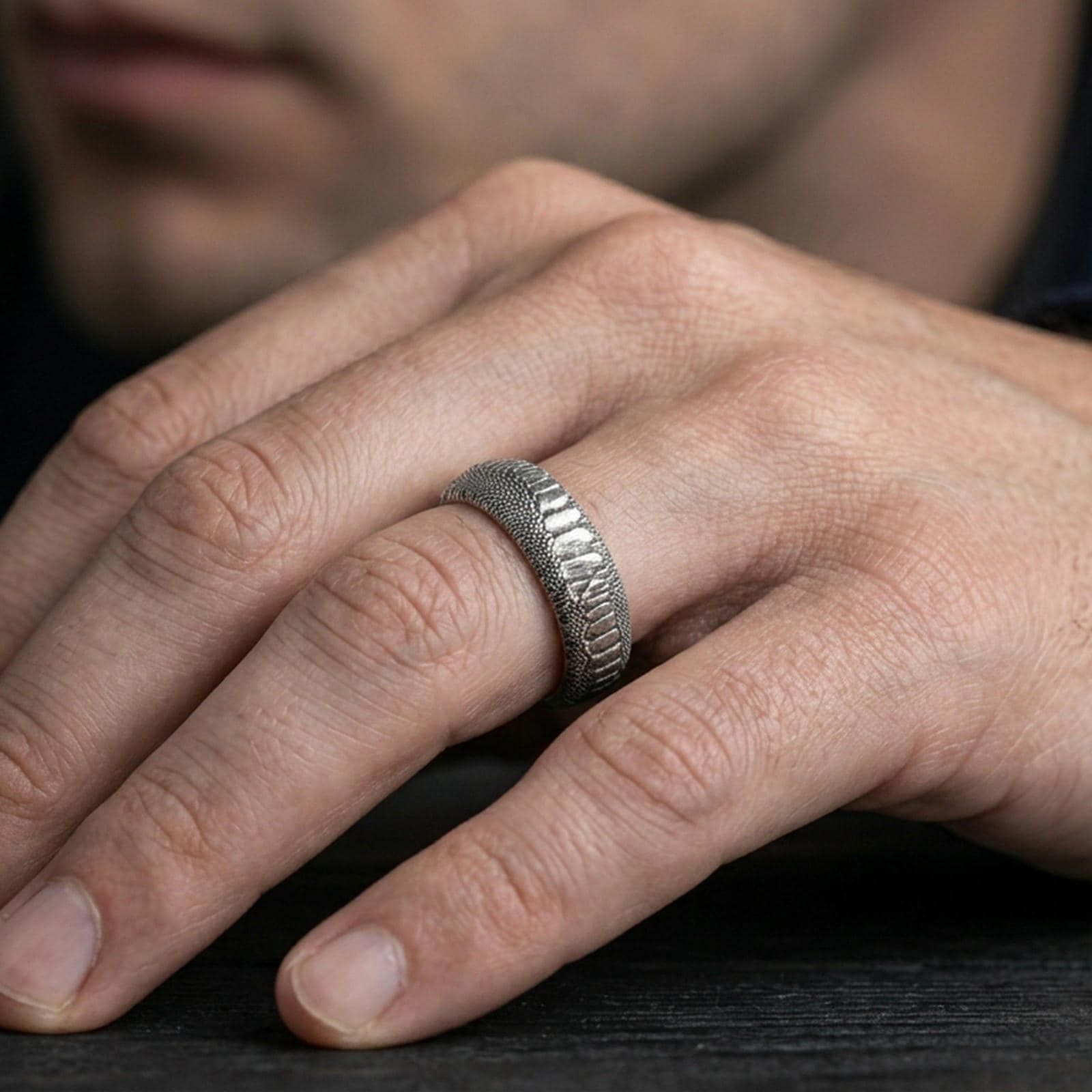 Oxidized sterling silver serpent skin band ring worn on finger, darkened scale relief for high contrast and a bold statement finish.