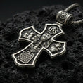 Load image into Gallery viewer, Holy Trinity cross pendant on black volcanic stone with deep oxidized contrast and crisp relief details.
