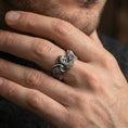 Load image into Gallery viewer, Oxidized sterling silver rooster ring worn on a finger, showcasing the dimensional rooster head and feathered band texture.
