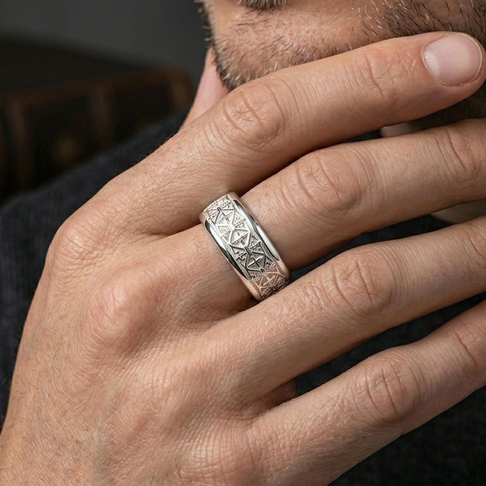 Polished silver fleur de lis band ring on a finger, clean shine with crisp engraved fleur symbols and geometric accents.