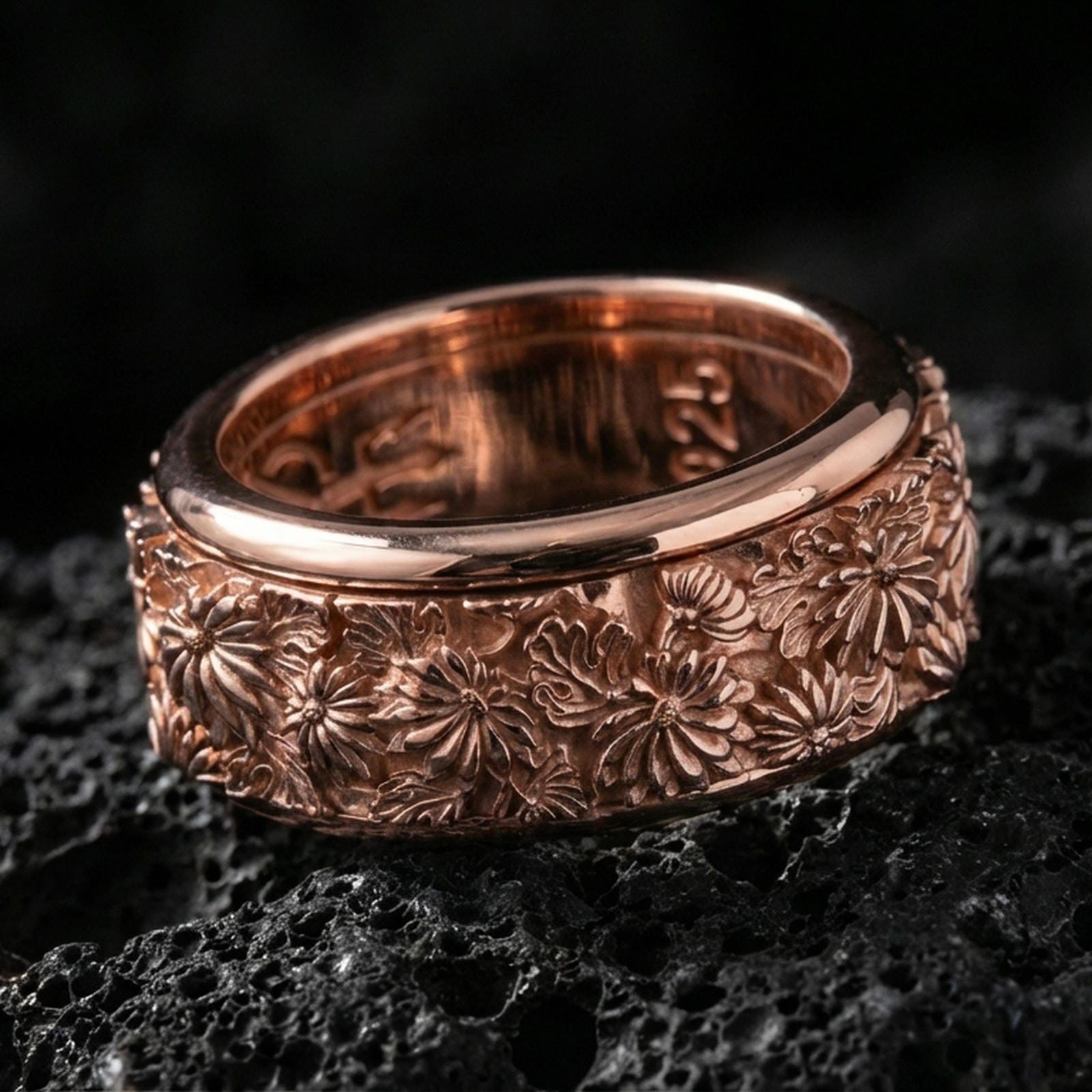 Floral spinner band on volcanic stone with a rose gold plated look, showing crisp daisy detailing and smooth rounded edges.