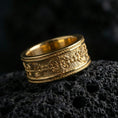 Load image into Gallery viewer, Engraved filigree ring displayed on volcanic rock with a gold plated finish, emphasizing the raised scrollwork and patterned edges.
