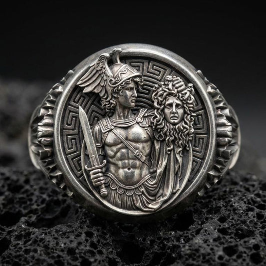 A 925 sterling silver Perseus and Medusa ring on black volcanic stone, oxidized contrast showing the myth relief scene.