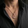 Load image into Gallery viewer, A rose gold plated Perseus and Medusa pendant worn on the neck, myth-inspired medallion necklace for statement wear.
