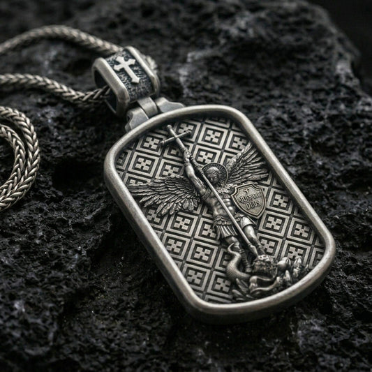 Saint Michael dog tag pendant on black volcanic stone with deep oxidized contrast, showing the archangel with spear and shield.