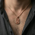 Load image into Gallery viewer, Saint Michael dog tag necklace worn on the neck in a lifestyle shot, showing the pendant’s full silhouette and chain pairing.
