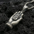 Load image into Gallery viewer, Buddha in protective hand pendant on black volcanic stone with deep oxidized contrast and vintage patina detail.

