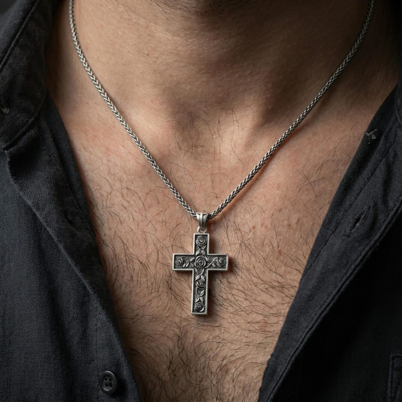 Oxidized rose cross pendant worn on the neck in a lifestyle jewelry shot, styled against the chest for a bold and devotional look