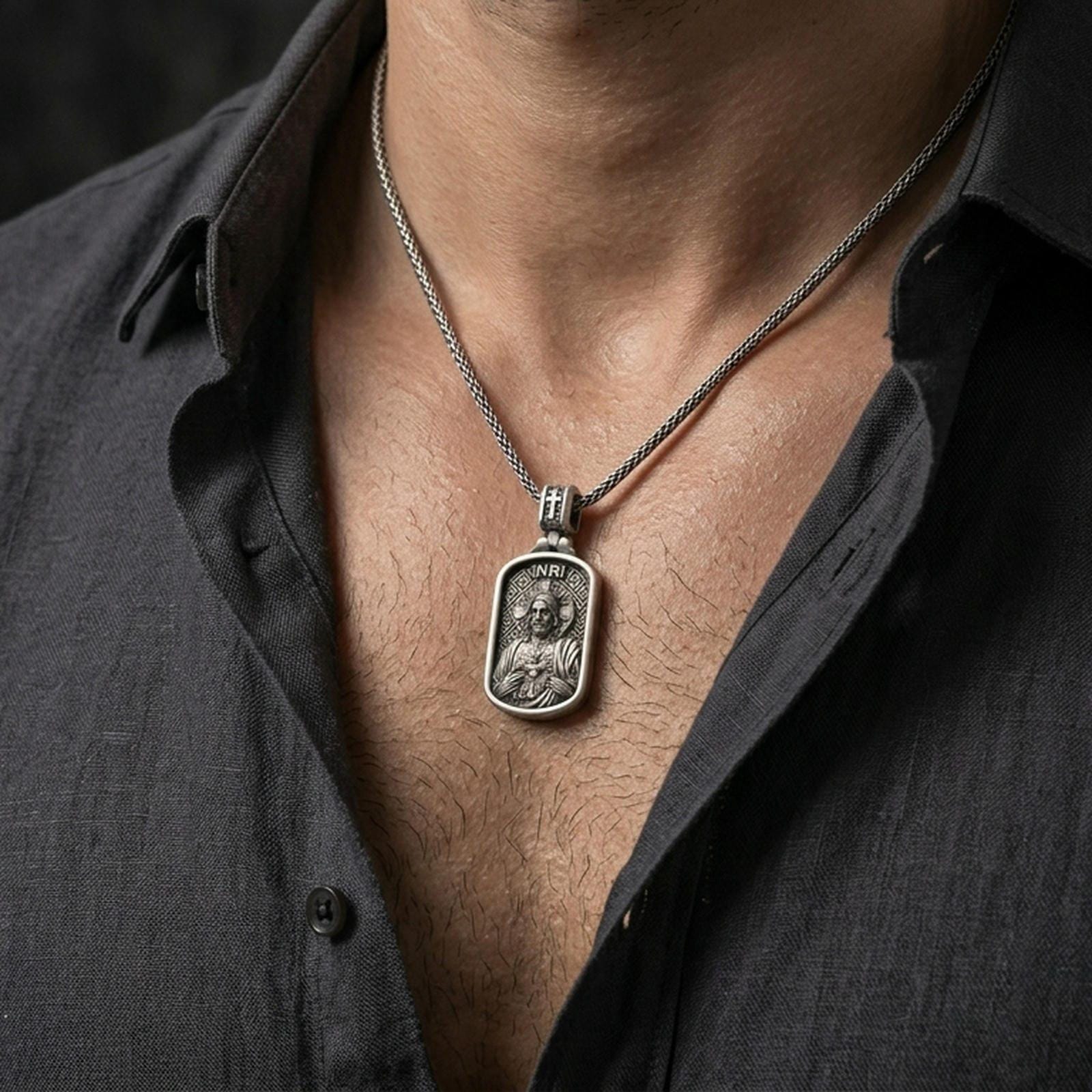 Oxidized Sacred Heart Jesus pendant worn on the neck in a lifestyle jewelry shot, styled against the chest for a bold and devotional look