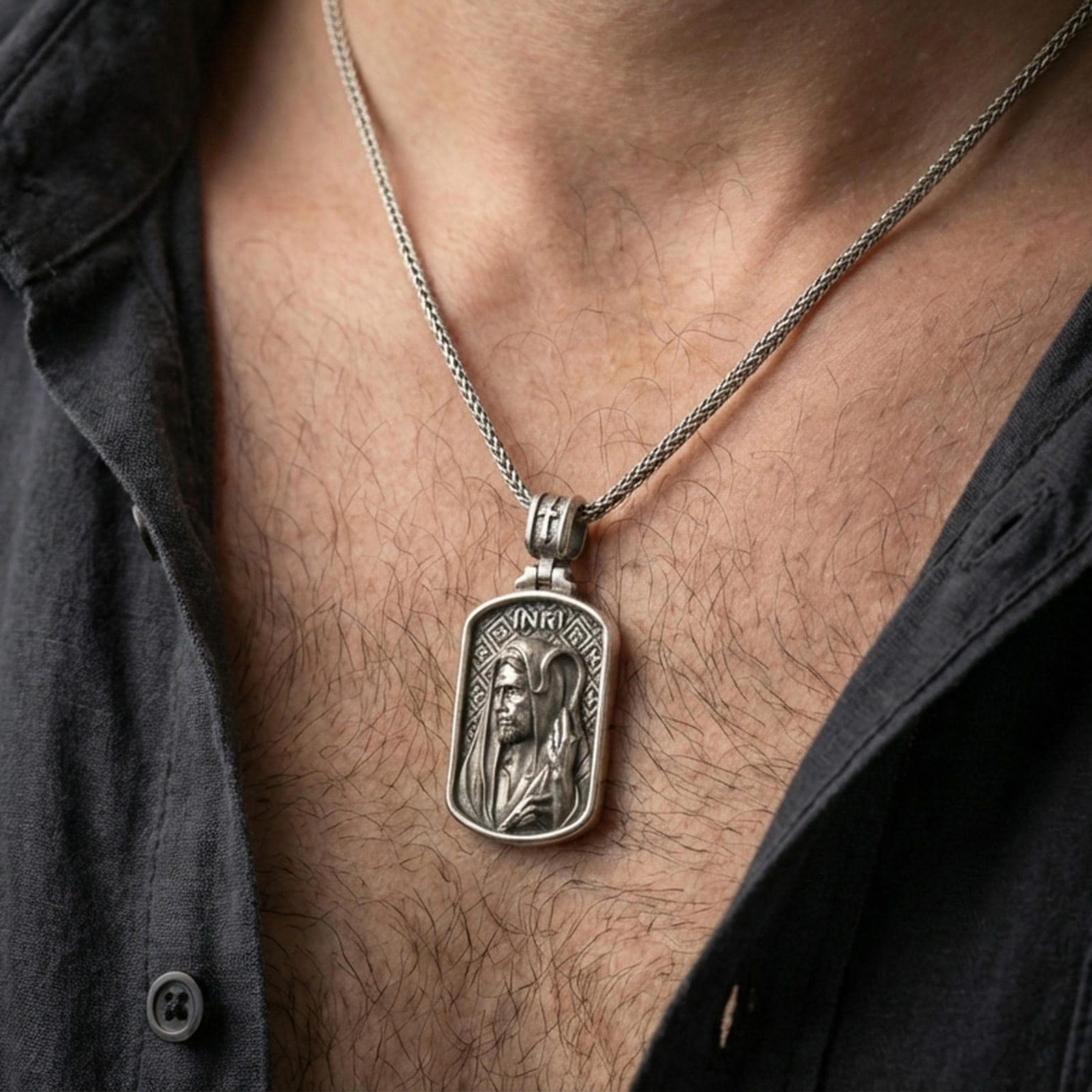 Oxidized Jesus pendant with shepherd staff worn on the neck in a lifestyle jewelry shot, styled against the chest for a bold and devotional look
