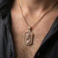 Load image into Gallery viewer, Rose gold plated religious Jesus pendant with INRI detail worn on the neck in a refined lifestyle shot with a warm and elegant presentation
