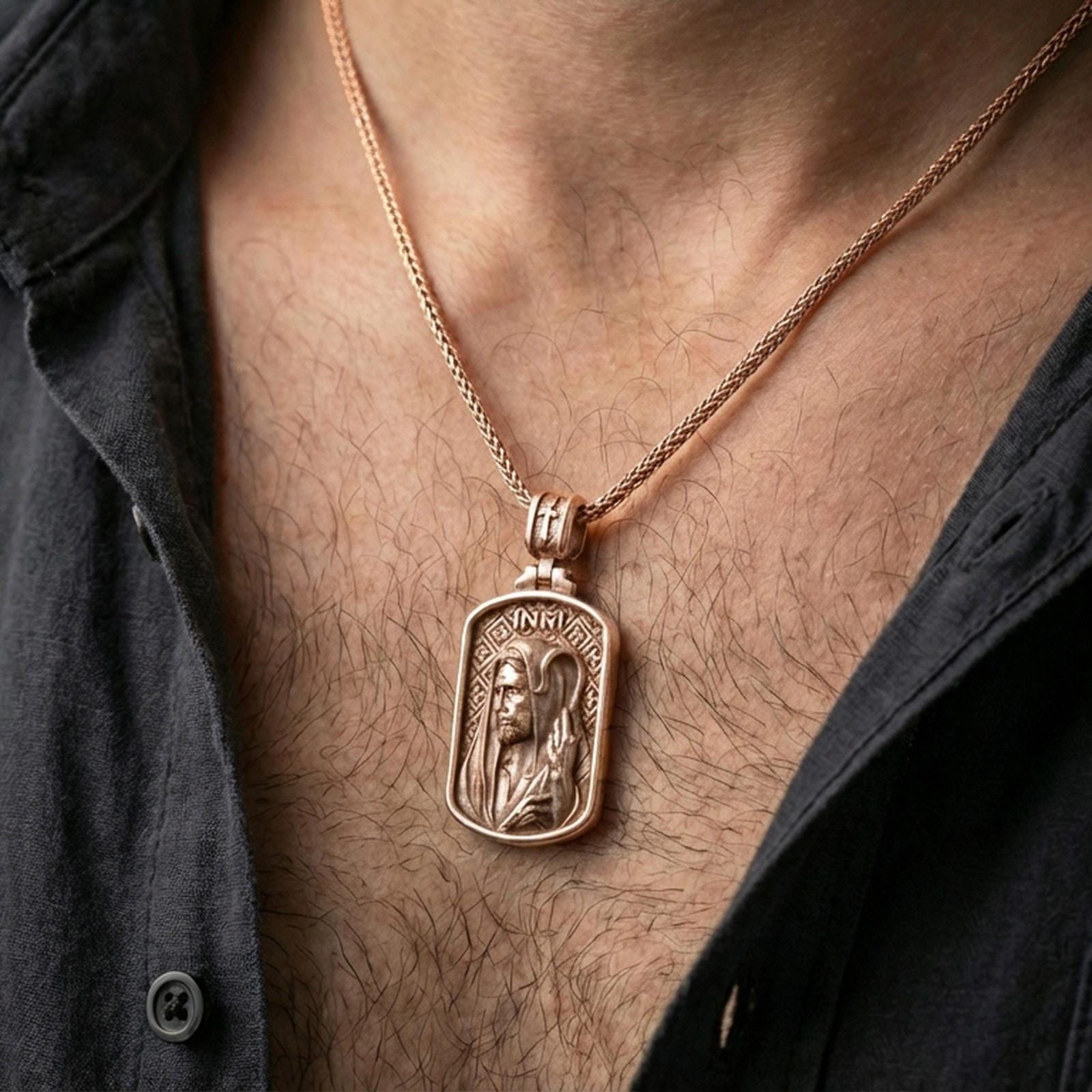 Rose gold plated religious Jesus pendant with INRI detail worn on the neck in a refined lifestyle shot with a warm and elegant presentation