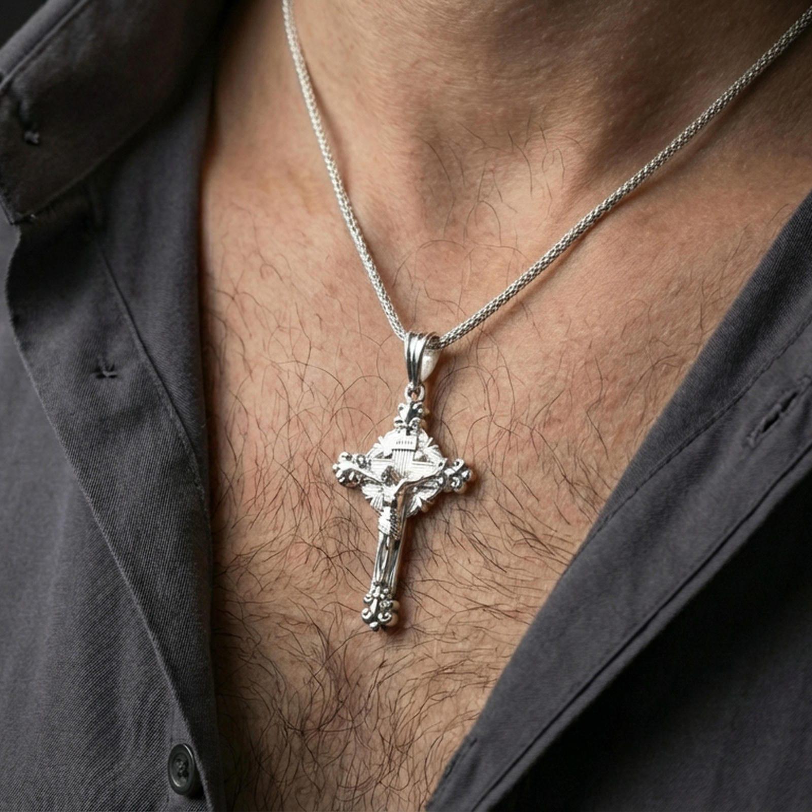Polished silver ornate cross pendant with INRI detail worn on the neck in a close lifestyle frame, highlighting the sculpted corpus and classic religious design