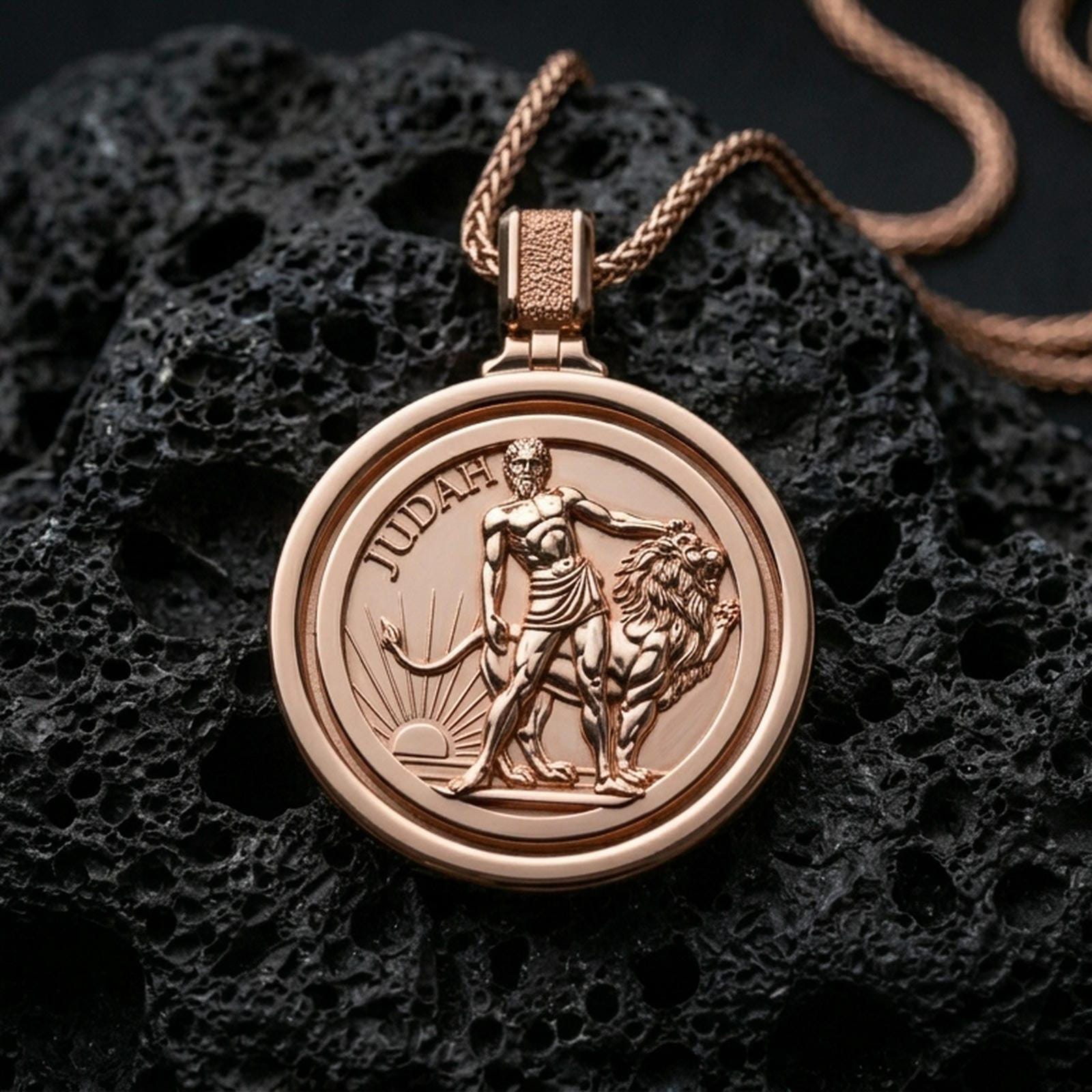 Rose gold plated Lion of Judah spinner pendant with detailed lion figure, round border, and symbolic engraved scene resting on volcanic rock in an elegant close-up product presentation